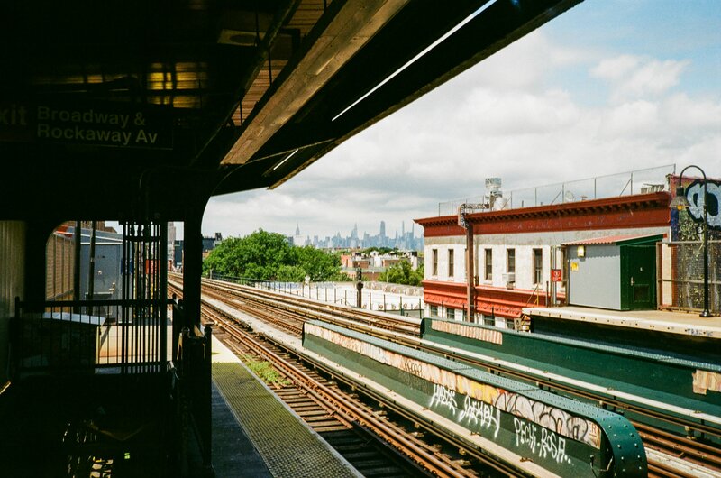 Subway station in Brooklyn NY with the NYC skyline far in the distance.