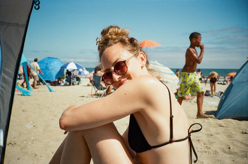 A women in a bikini sitting on the beach