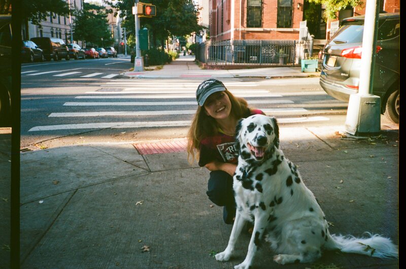 A women and her dalmation dog on the streets of Brooklyn, NY.